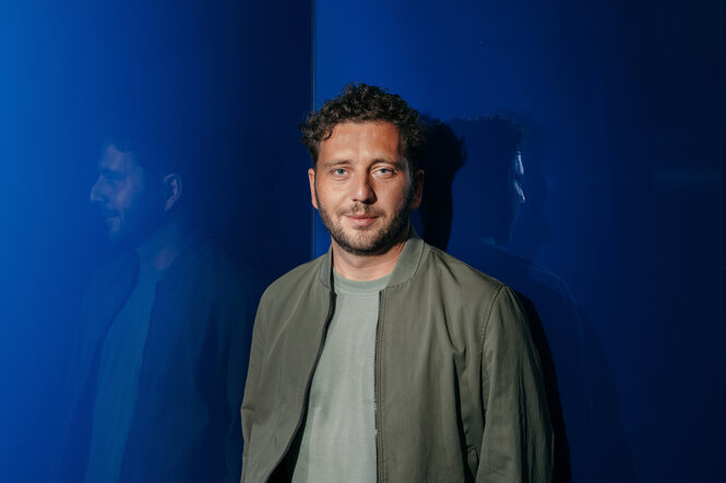 Mann vor blauem Hintergrund