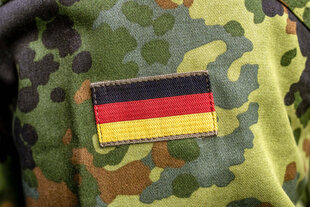 Auf dem Flecktarn Muster einer Bundeswehrs-Uniform ist eine kleine Deutschlandflagge genäht