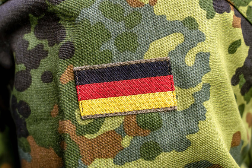 Auf dem Flecktarn Muster einer Bundeswehrs-Uniform ist eine kleine Deutschlandflagge genäht