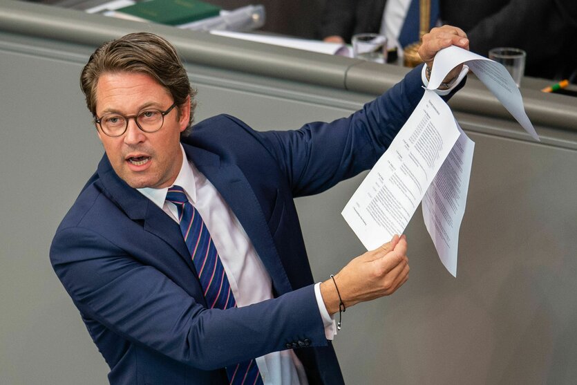 CSU-Politiker Andreas Scheuer steht im Bundestag und hält Papiere hoch