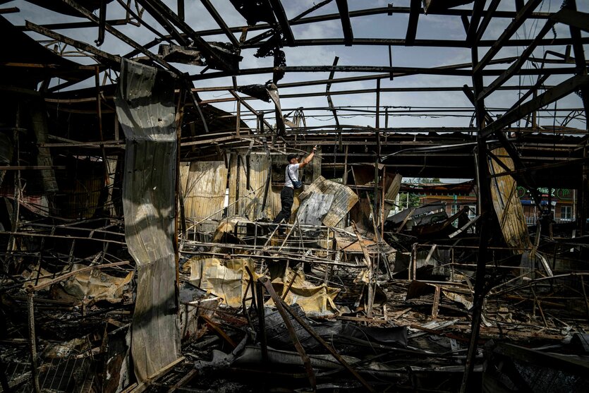 Ein Mann sammelt in Nikopol Kupferdrähte in einem durch russischen Beschuss zerstörten Markt