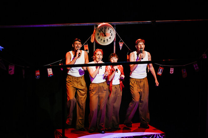 Vier SchauspielerInnen mit decklungsgleichen Garderobe singen unter einer Uhr, Szene aus "Internal Climate"