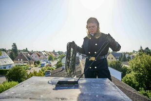 Pauline Große auf dem Dach. Sie macht gerade den Schornstein sauber.
