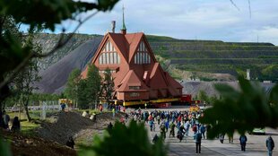 Menschen betrachten eine Kirche auf Rädern