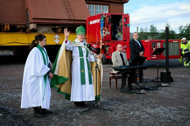 Vier Personen während eines Gottestdienstes vor einer Kirche