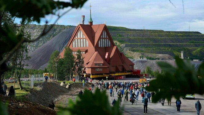 Menschen betrachten eine Kirche auf Rädern