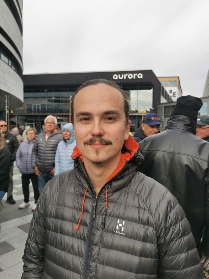 Ein Mann mit Daunenjacke lächelt in die Kamera