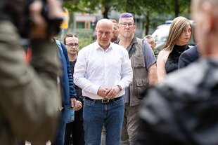 Kai Wegner steht in einer diversen Gruppe