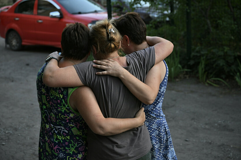 drei Frauen von hinten die sich umarmen