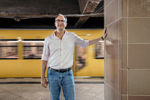 Ein Mann steht vor einer einfahrenden U-Bahn