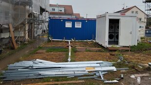 Auf einer Baustelle stehen Container mit Waschmaschinen