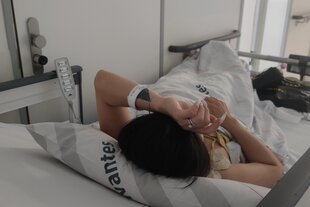 Linh Nguyen, die eigentlich anders heißt, liegt auf einer Schiebeliege in einer Klinik