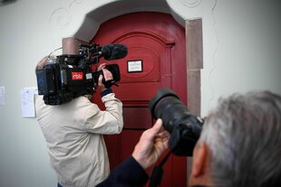 Ein RBB-Kameramann filmt eine Tür zum Gerichtssaal
