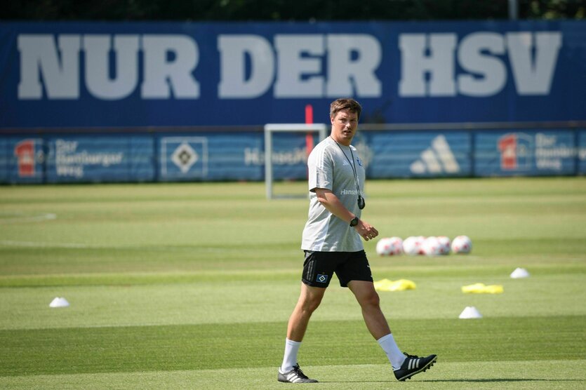 Merlin Polzin auf dem Platz vor einer Bande mit der Aufschrift "Nur der HSV"