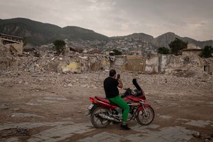 Motorradfahrer fotografiert im erdbebenzerstörten Antakya