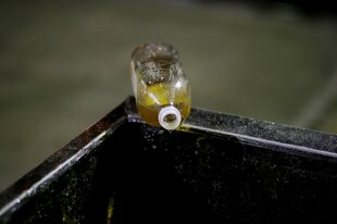 Speiseölflasche auf dem Rand eines großen Öltanks