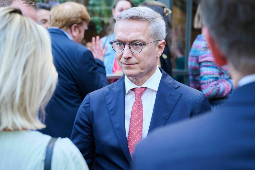 Karsten Wildberger im Gespräch mit einer Frau, die man nur in der Rückenansicht sieht