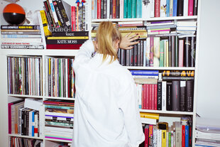 Frau wendet sich einem Bücherregal zu