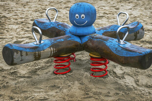Ein gefedertes Spielgerät steht im Sand