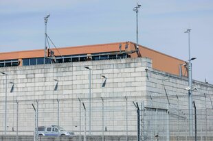 Zwischenlager auf dem Gelände des Forschungszentrum Jülich (AVR Behälterlager). Das Gebäude aus hellen Steinen hat ein rotes Dach und steht hinter einem Zaun