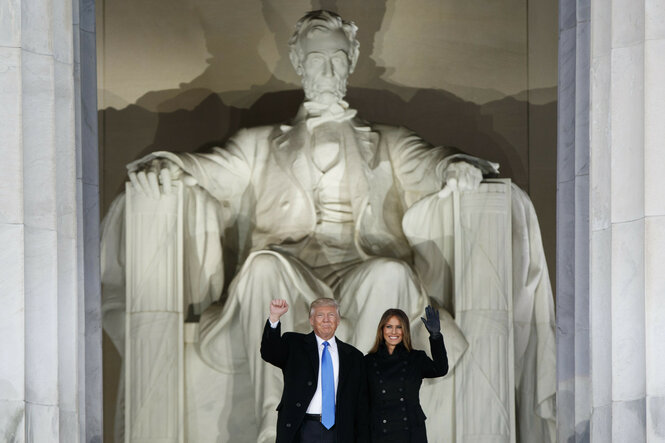 US-Präsident Donald Trump (l) und die first lady Melania Trump stehen Lincoln Memorial in Washington D.C. und winken mit erhobenen Armen.