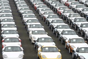 Reihen von Porsches unter weißen Folien zum verladen bereit