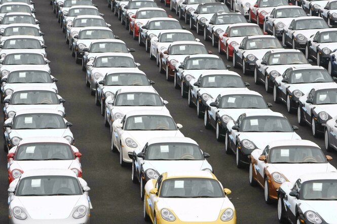 Reihen von Porsches unter weißen Folien zum verladen bereit