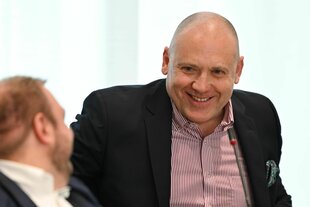 Joachim Paul nimmt an der Plenarsitzung des Landtags Rheinland-Pfalz teil und grinst schelmisch