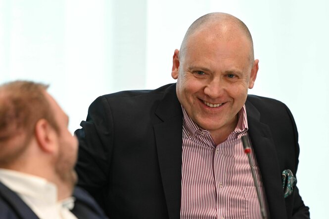 Joachim Paul nimmt an der Plenarsitzung des Landtags Rheinland-Pfalz teil und grinst schelmisch