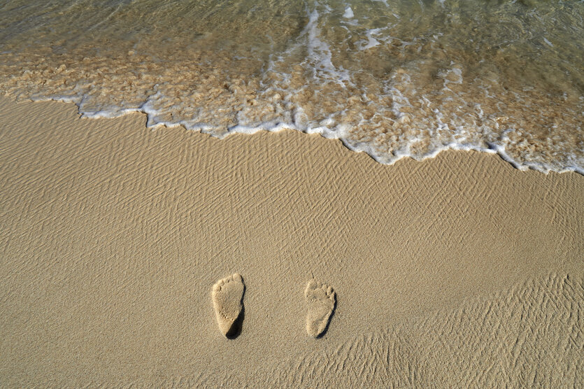Fußabdrücke an einem Strand.