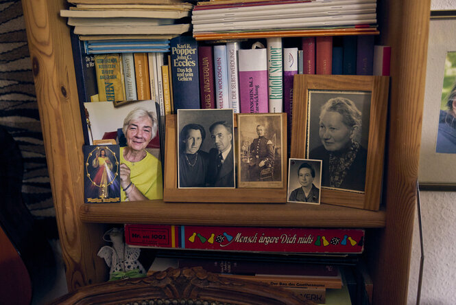 Familien-Bilder stehen in einem Bücherregal.