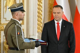 Karol Nawrocki schielt auf eine von einem Sodlaten gehaltenes Tablett