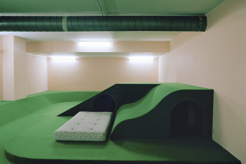 Ein Zimmer mit grüner Couch und grünem Boden