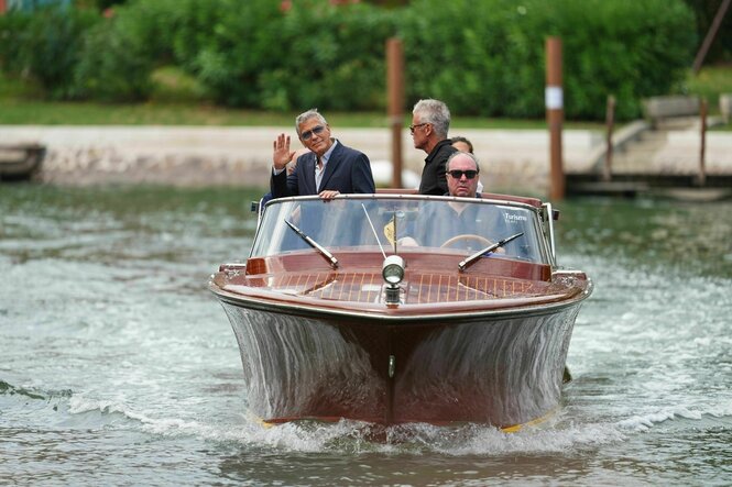 George Clooney winkend auf einem Motorboot