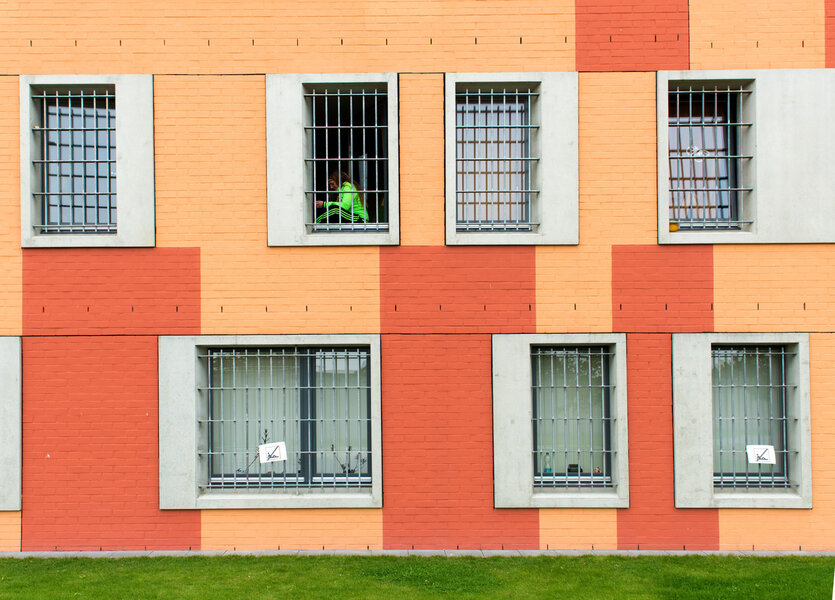 Eine Gefangene schaut aus dem Zellenfenster in der Justizvollzugsanstalt
