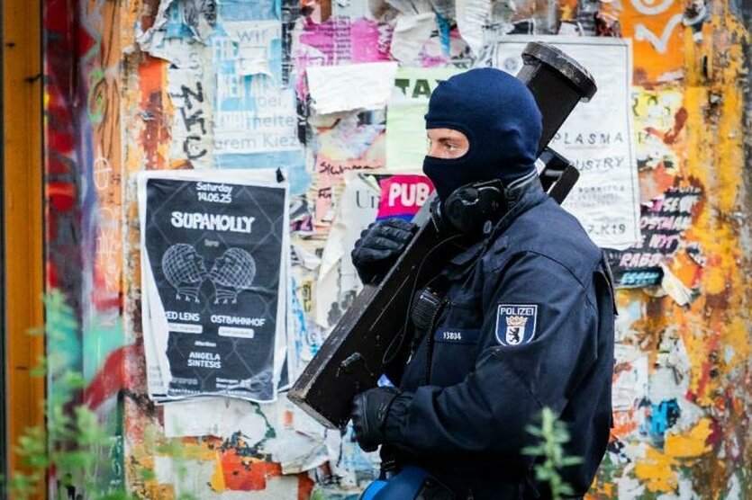 Ein Polizist vor einer Wand mit Graffiti und Flyern