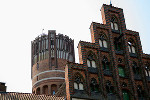 Lüneburgs Wasserturm neben einer Backsteinfassade