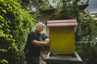 Frau an einem Bienenstock