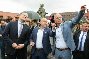 Spahn, Hoffmann und Miersch zeigen vor Journalisten auf eine Würzburger Attraktion