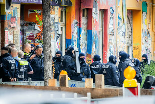 Polizisten stehen vor einem Wohnhaus