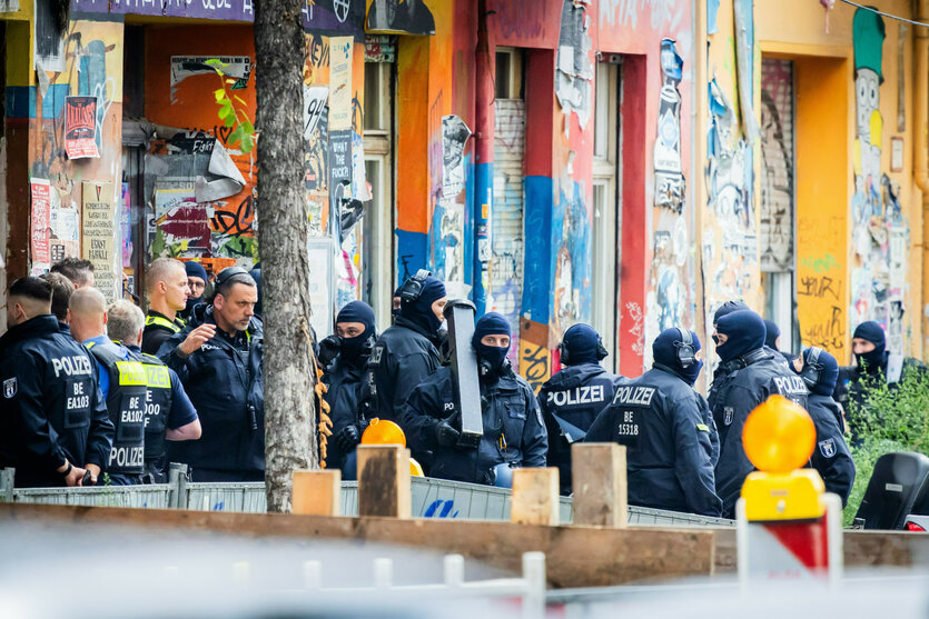Polizisten stehen vor einem Wohnhaus