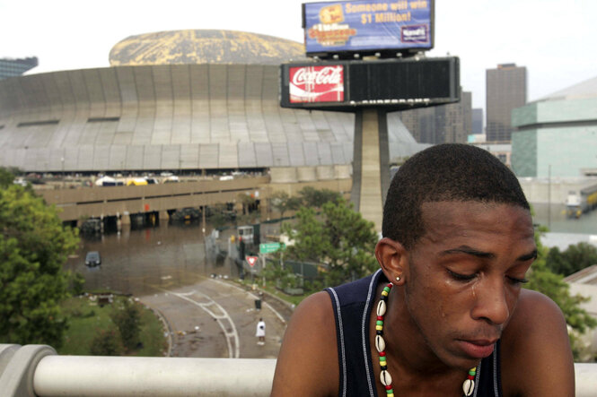 Ein junger Mann weint, im Hintergrund das Football-Stadion von New Orleans