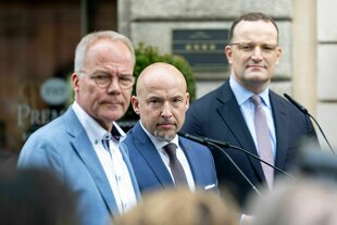 Die drei Fraktionsvorsitzenden blicken grimmig über die Schulter in die Kamera