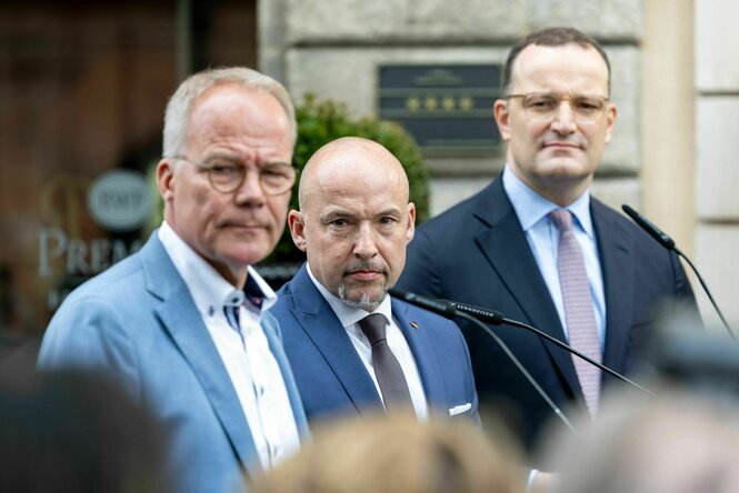 Die drei Fraktionsvorsitzenden blicken grimmig über die Schulter in die Kamera