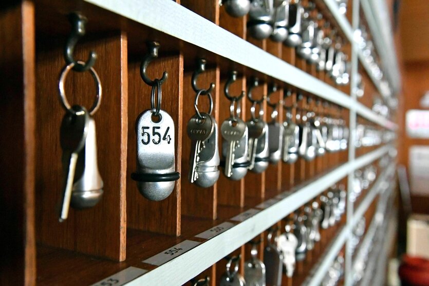 In einem Holzregal hängen Hotelschlüssel