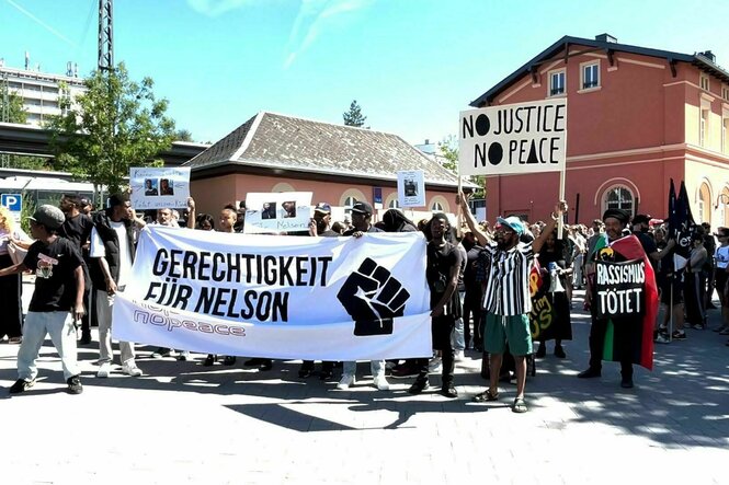 Menschen fordern «Gerechtigkeit für Nelson» vor dem Gefängnis und mit einem großen Transparent