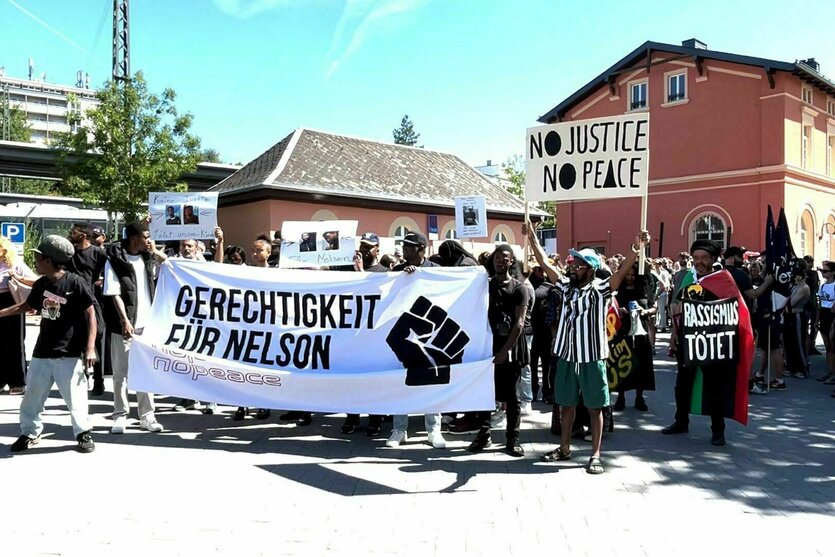 Menschen fordern «Gerechtigkeit für Nelson» vor dem Gefängnis und mit einem großen Transparent