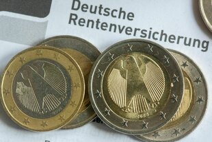 Münzen liegen auf einem Rentenbescheid