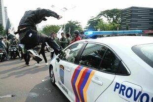 Student springt gegen Polizeiautoscheibe