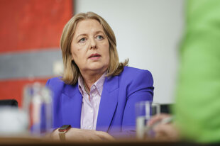 Eine Frau im violetten Blazer (Bärbel Bas) schaut interessiert